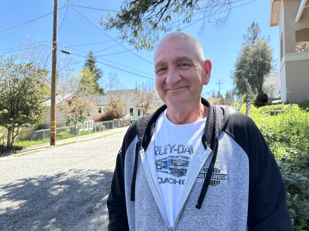 Quinn Coburn sits on a sunny street in Grass Valley.