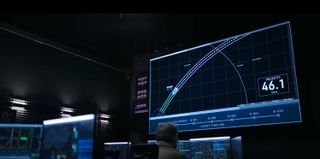 a dark mission control room with a tracking screen