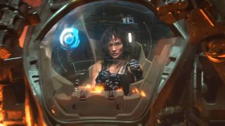 a woman in a cockpit pilots a giant robot in an exo-suit