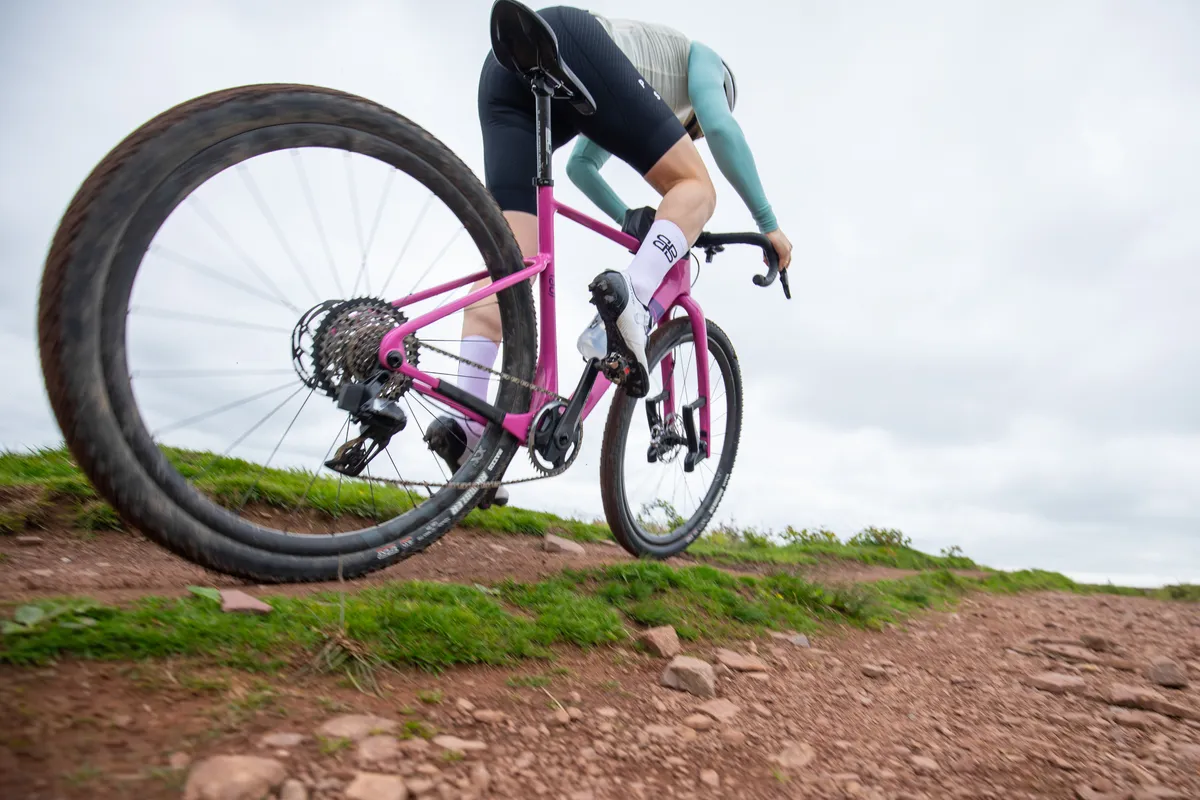 Wide angle shot of a man riding Lauf Seigla on a gravel track