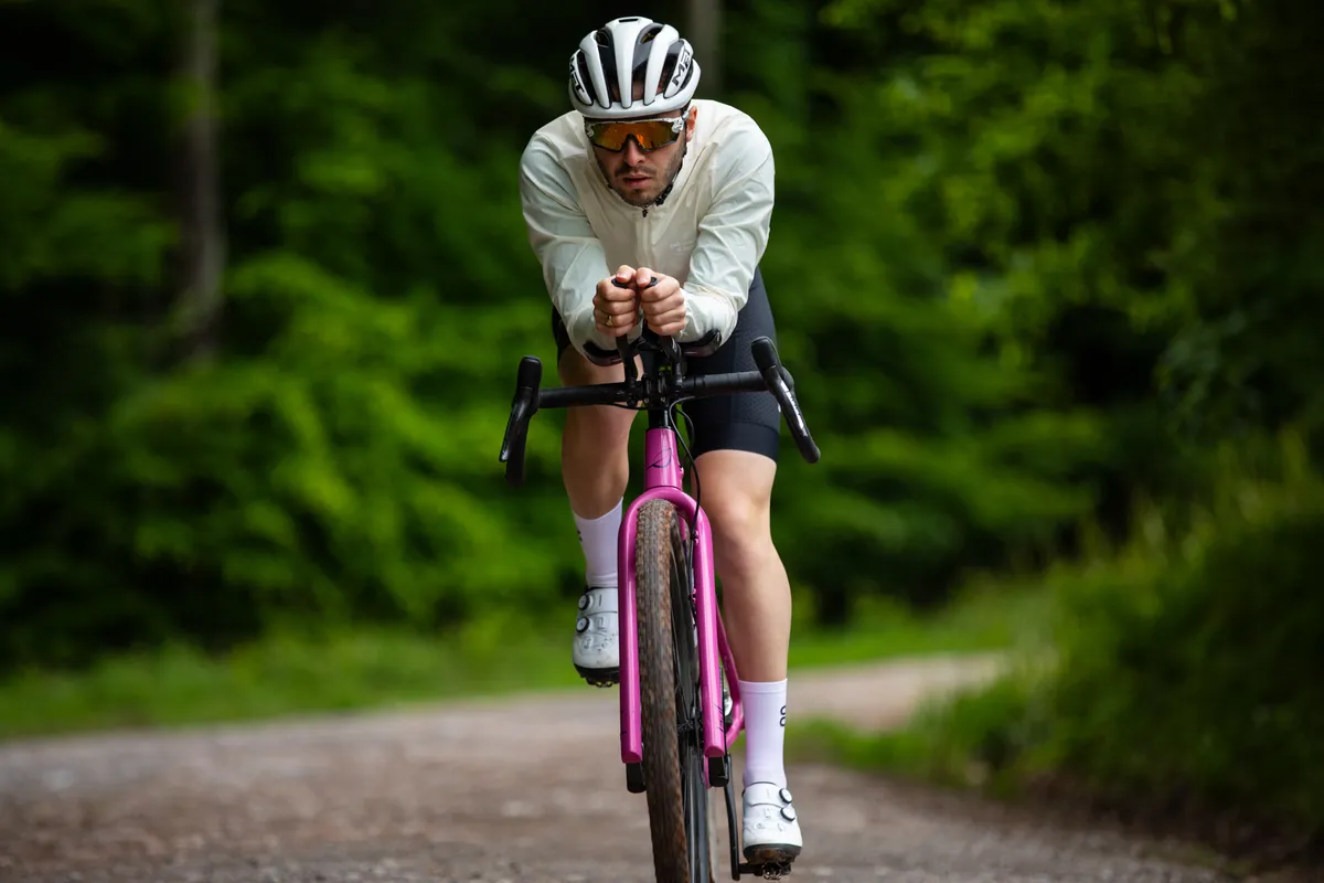 Man riding aero extensions wearing white cycling jacket