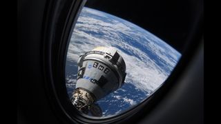 a gray and blue cone shaped spaceship seen through a window with earth below