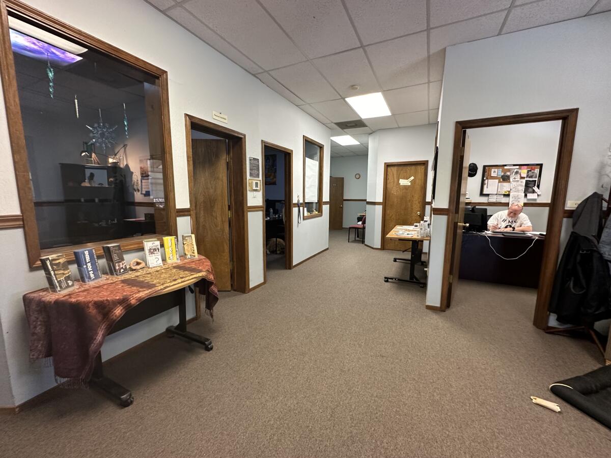 A large, clean office interior with glass windows and brown carpet   