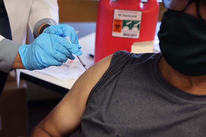 In this file photo, a pharmacist gives a booster shot of the COVID-19 vaccine in Chicago.