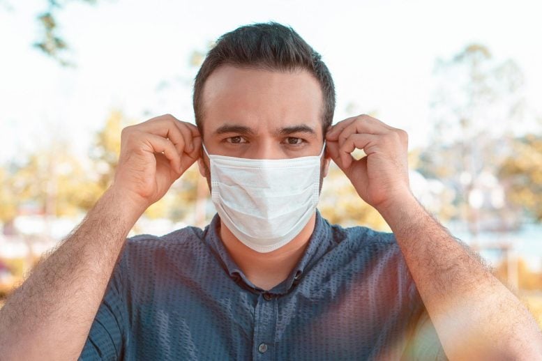 Man putting on COVID face mask