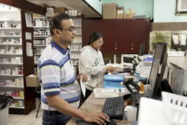 Prakash Patel, owner and pharmacist, foreground, works at Bert's Pharmacy in Elizabeth, New Jersey, May 21, 2024. (AP Photo/Shelby Lum)