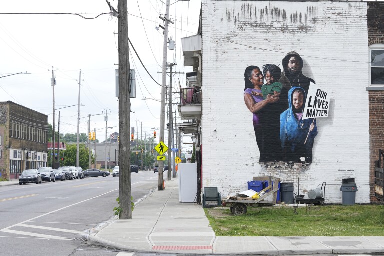 A mural is pictured on a nearly empty street near the MAC Pharmacy, Wednesday, May 29, 2024, in Cleveland.  An Associated Press analysis of licensing data from 44 states, data from the National Council on Prescription Drug Programs and the American Community Survey shows that residents of majority black and Hispanic neighborhoods have fewer pharmacies per capita than people living in predominantly white neighborhoods.  (AP Photo/Sue Ogrocki)