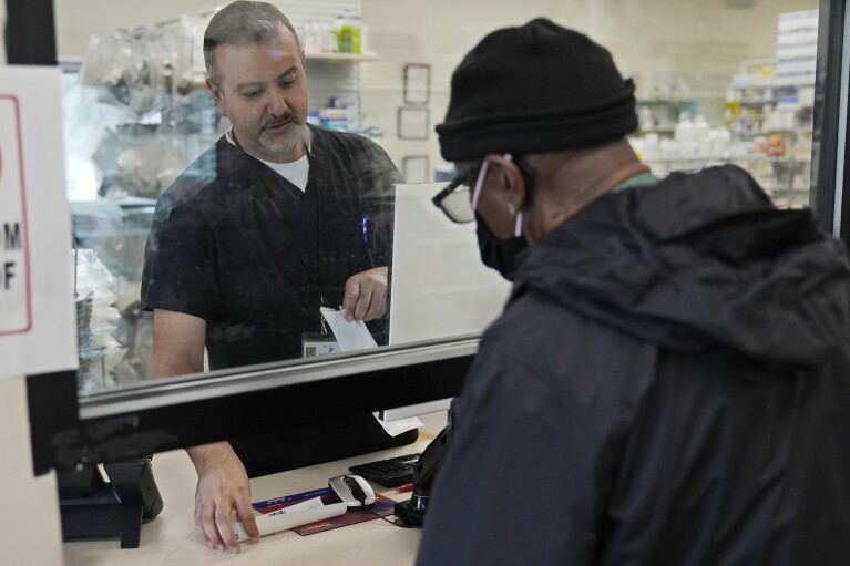 Pharmacist George Tadross attends to a customer at MAC Pharmacy, Wednesday, May 29, 2024, in Cleveland.  Pharmacists play a role in managing chronic conditions like diabetes and heart problems, which Black and Hispanic people are more likely to be diagnosed with.  (AP Photo/Sue Ogrocki)