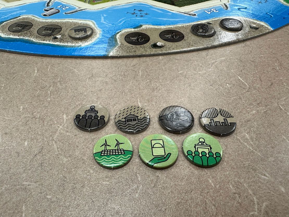 Event markers in Catan: New Energies determine positive or negative effects in the game. The brown markers, on the left, represent a conference on climate, rain and floods, environmental pollution and pollution of the air.