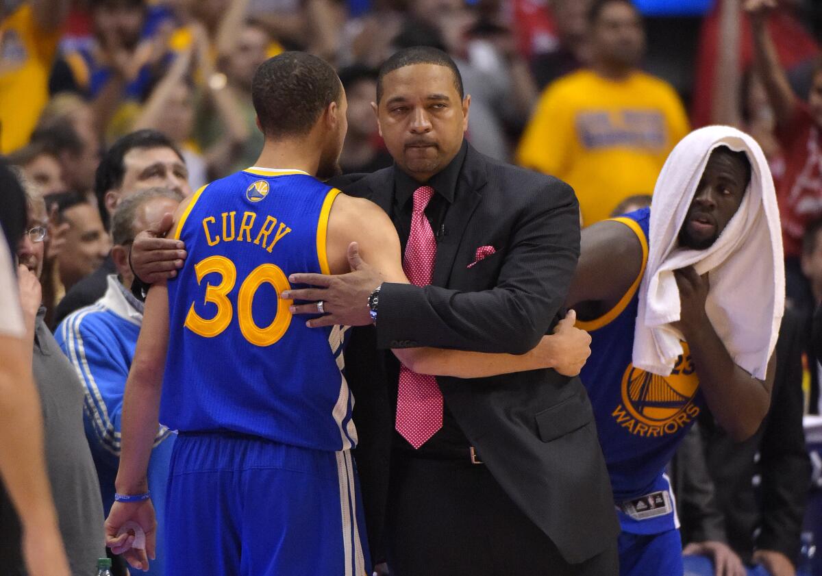 Warriors head coach Mark Jackson hugs guard Stephen Curry after he was knocked out of a playoff game against the Clippers.