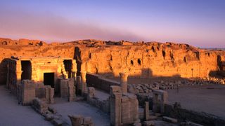 The sunrise begins to wake up the ruins of the small temple in front of the larger, already lit remains of the Temple of Horus.