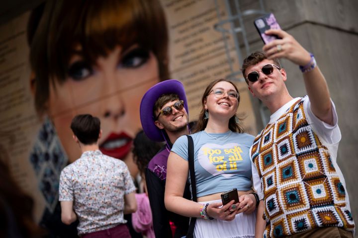 Taylor Swift fans pose for a photo next to a mural, commissioned by Mayor of London Sadiq Khan, ahead of the Eras Tour's first London concert, Friday June 21, 2024 in London.  (Photo by Scott A. Garfitt/Invision/AP)