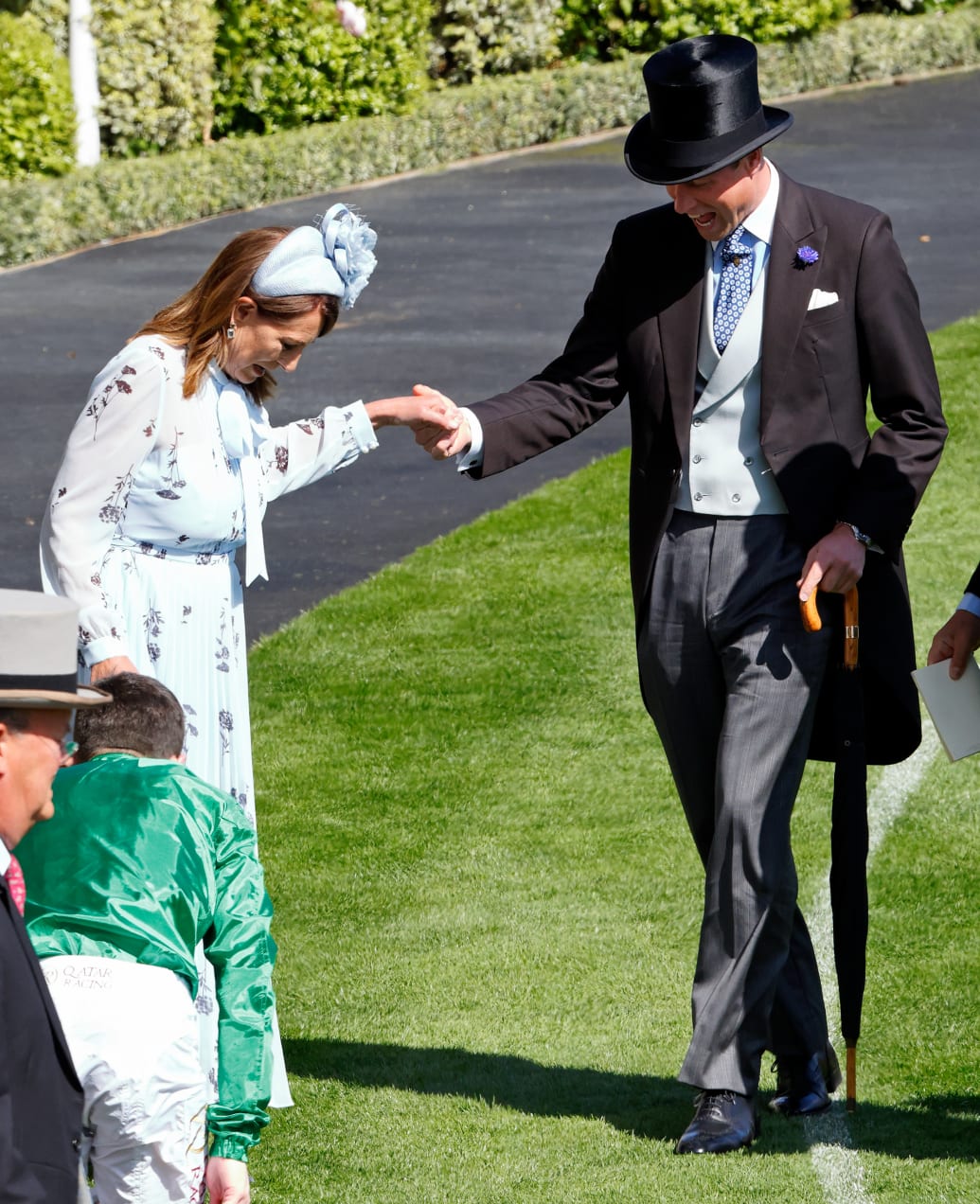 Prince William, Prince of Wales, assists Carole Middleton as she wedges the heel of her shoe into the grass during day two of Royal Ascot 2024 at Ascot Racecourse on June 19, 2024 in Ascot, England. England.