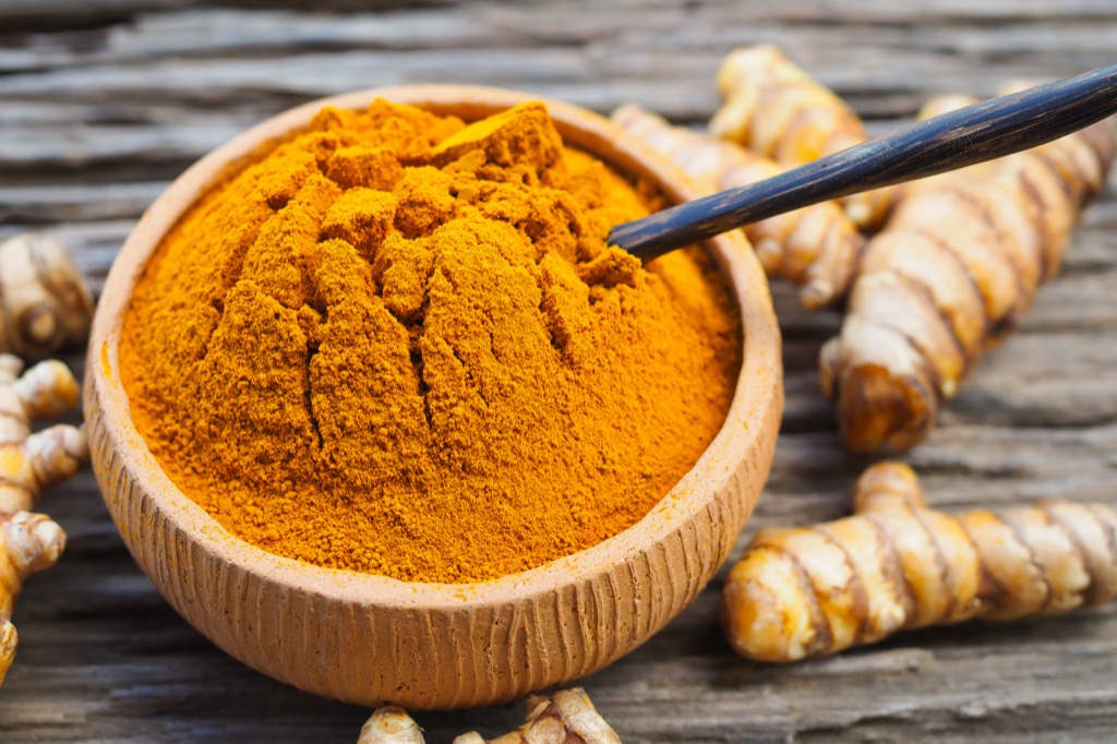 turmeric curcumin powder surrounded by turmeric root