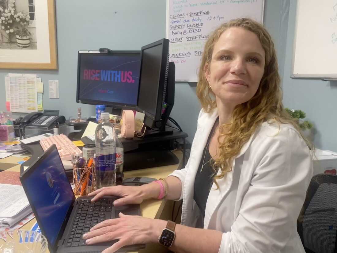 Kathryn Dixon, AtlantiCare's chief nursing officer, sits with her laptop at a desk.