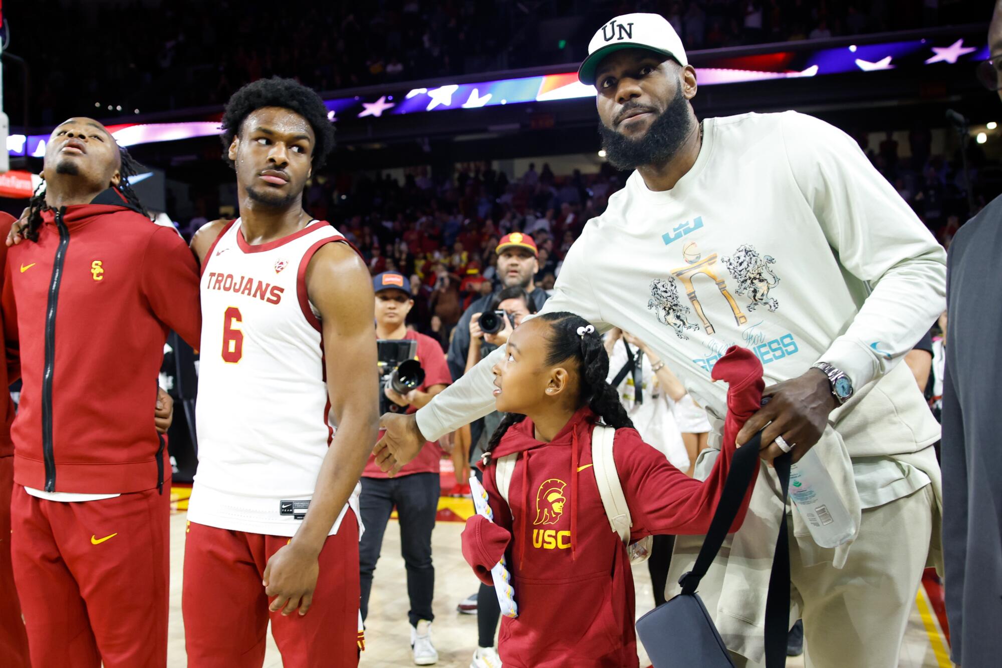 Lakers star LeBron James, right, pats Bronny James on the back before his college debut against Long Beach State in December.