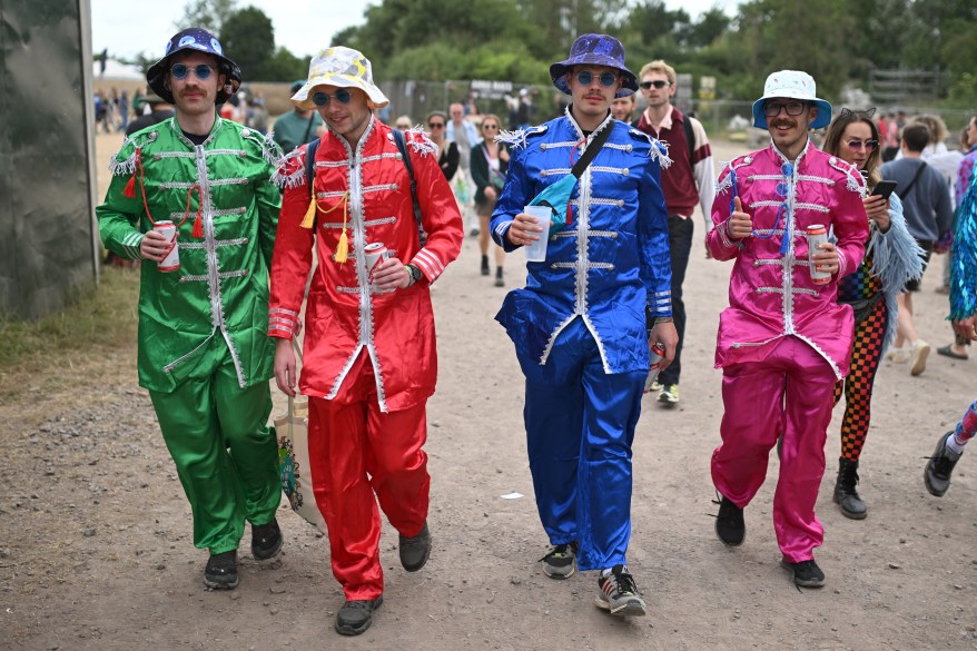 Festival-goers dressed as the Beatles attend.