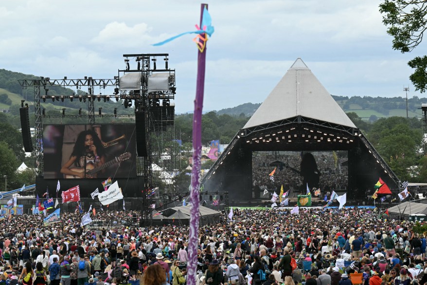 Festival-goers watch Olivia Dean perform on the Pyramid Stage.