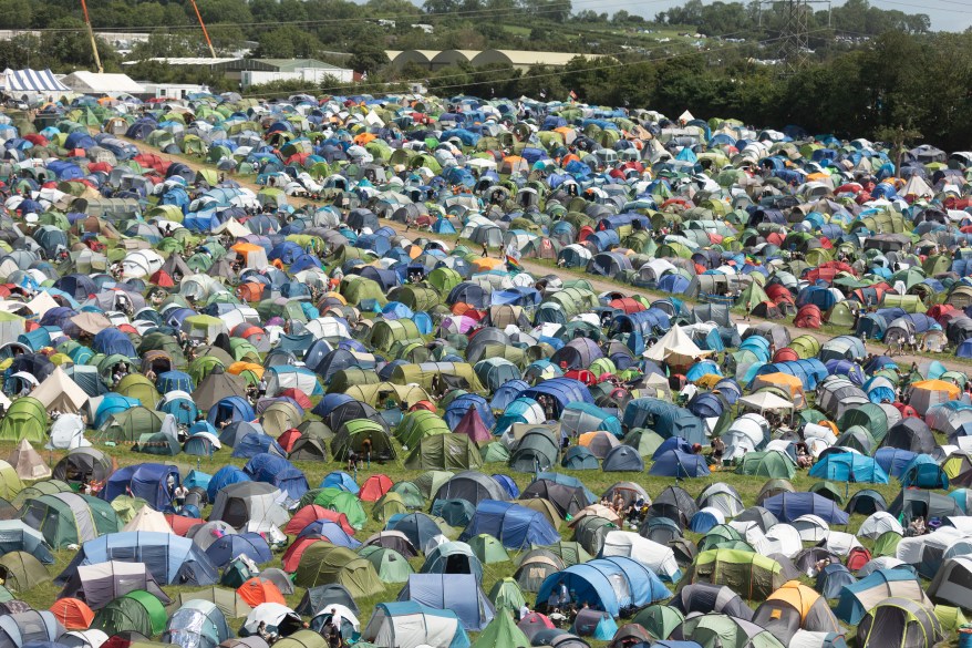 People wander around the tents set up at the main campsites.