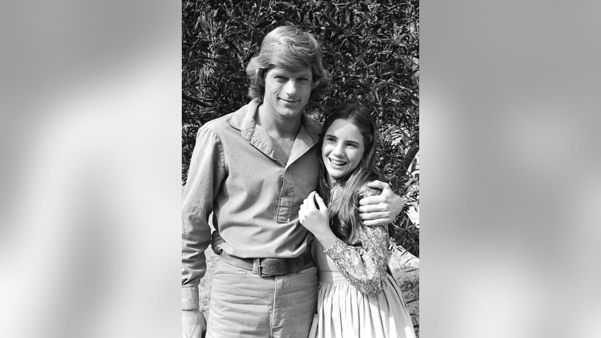 Melissa Gilbert smiling and hugged by Dean Butler.