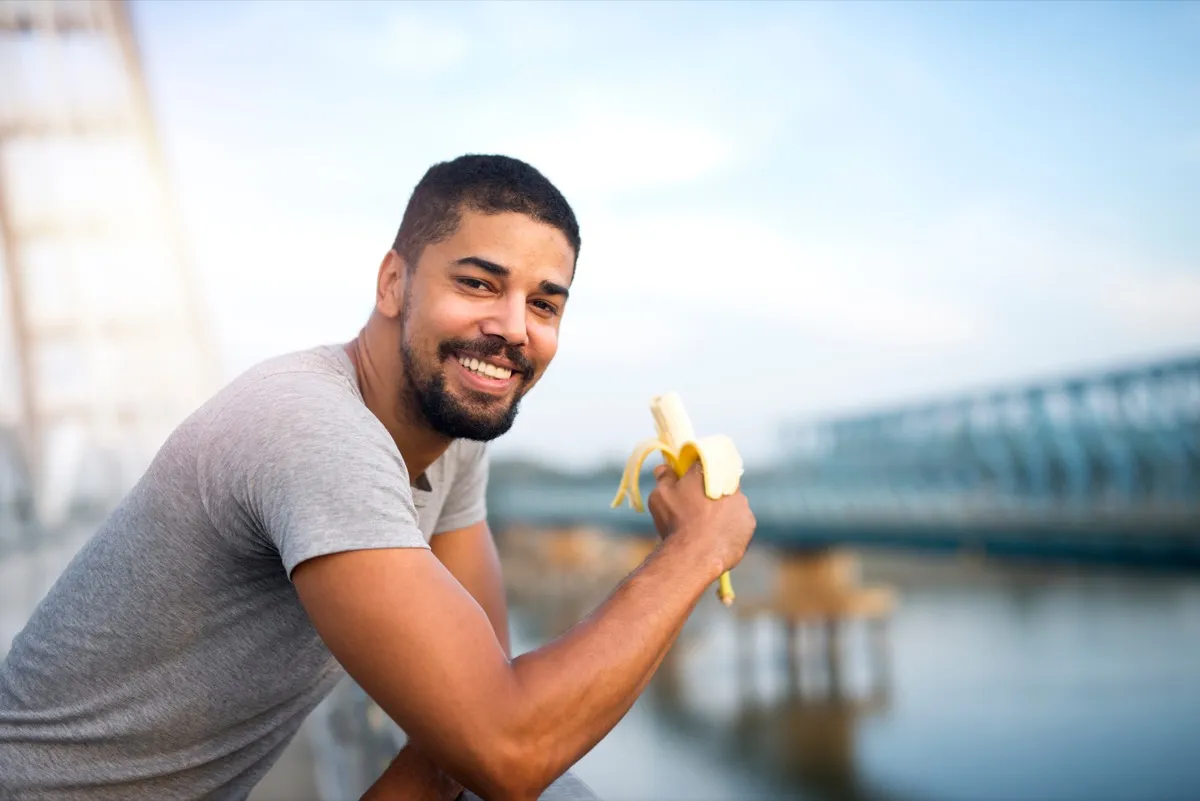 A man eating a banana outside