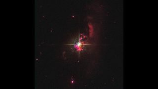 a bright cross of light with red gas scattered around it in space.