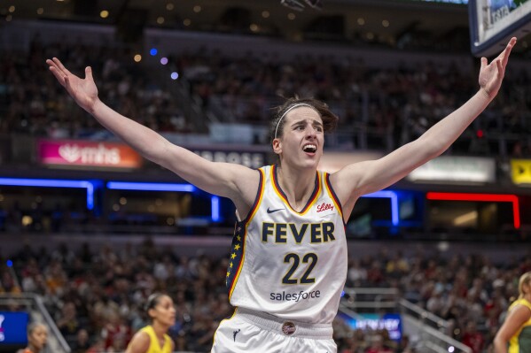 FILE - Indiana Fever guard Caitlin Clark reacts after scoring against the Seattle Storm during the first half of a WNBA basketball game, May 30, 2024, in Indianapolis.  Even a WNBA basketball game can't escape the arguments and polarization that are so common in American life these days.  (AP Photo/Doug McSchooler, file)