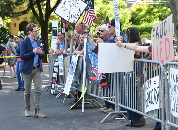 Dominican University psychology professor Ben Rosenberg walks past a group of anti-vaccine protesters before Dr. Anthony Fauci's appearance at Dominican University in San Rafael, Calif., Tuesday, June 25, 2024. (Sherry LaVars/ Marin Independent Journal)