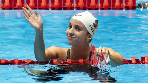 Regan Smith waves to the crowd after winning the 100-meter backstroke preliminary heat at the 2024 United States Olympic Swimming Trials