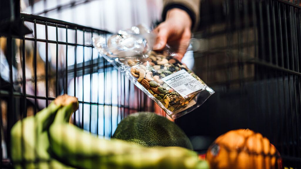 a person's hand holding a bag of nuts