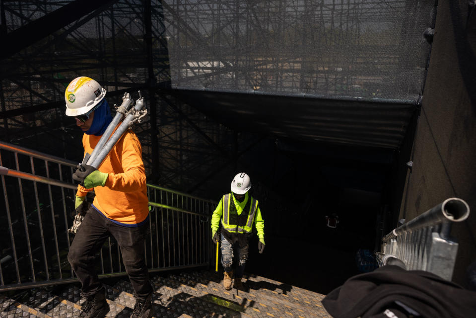 Construction workers carry equipment as they construct the Nassau County International Cricket Stadium for the upcoming ICC Men's T20 World Cup at Eisenhower Park in East Meadow on May 1, 2024 in New York.  Nassau County International Cricket Stadium under construction at Eisenhower Park in East Meadow, New York, ahead of the 2024 ICC T20 World Cup. The new Nassau County International Cricket Stadium near New York has been launched May 15, 2024 with the world body sport 