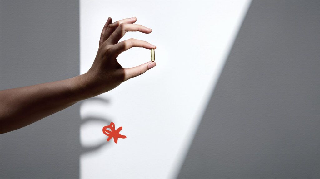 A person holding an omega-3 pill.