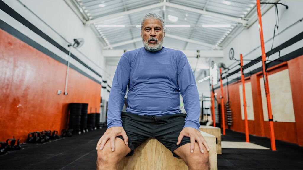 An older man sits at the gym