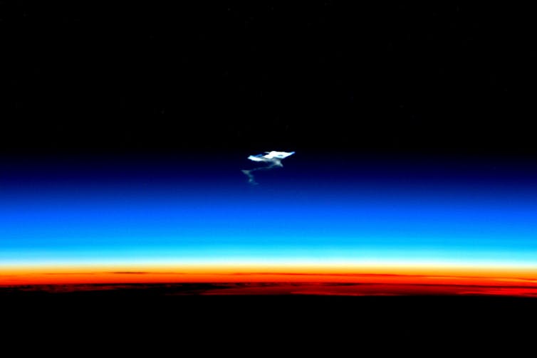 Photo showing a plume of smoke floating above the Earth's atmosphere.