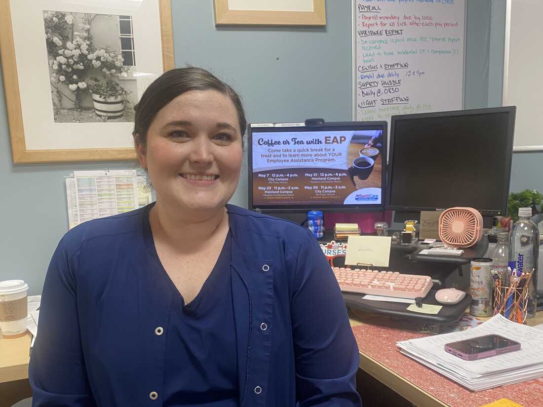 Nurse manager Danielle DiLella sits in her office, with a long to-do list on her whiteboard behind her.