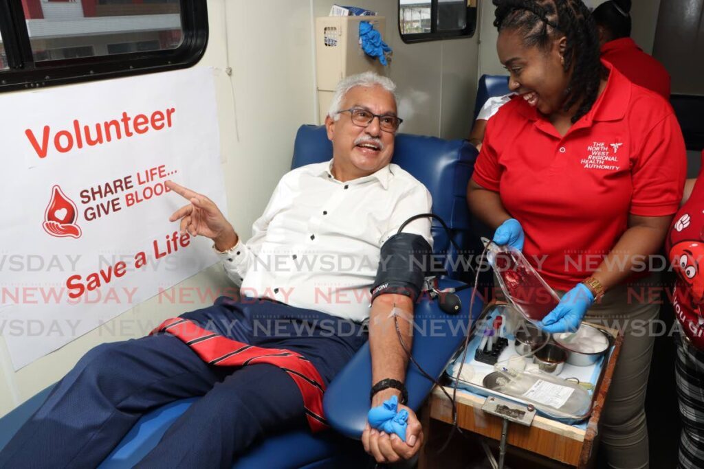 Health Minister Terrence Deyalsingh donates blood on June 14, World Blood Donor Day, at a mobile unit located on Brian Lara Drive in Port of Spain.  - Photo by Angelo Marcelle