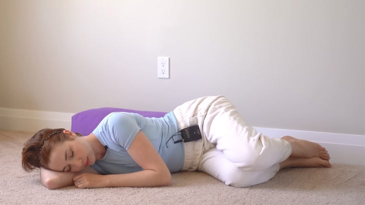 woman practicing yoga near a wall next to him