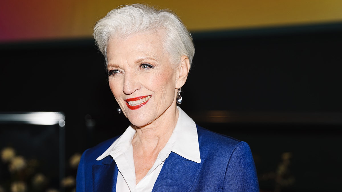 Close up of Maye Musk wearing a blue blazer and white blouse