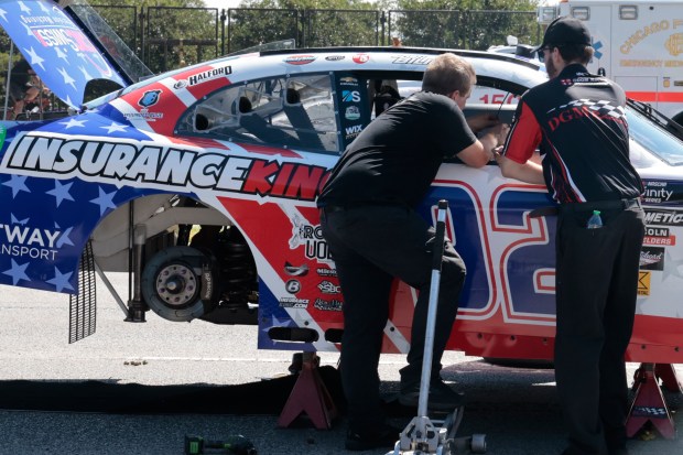 Race cars are examined after being unloaded from trucks ahead of the Chicago NASCAR street race along DuSable Lake Shore Drive on July 5, 2024. (Antonio Perez/Chicago Tribune)