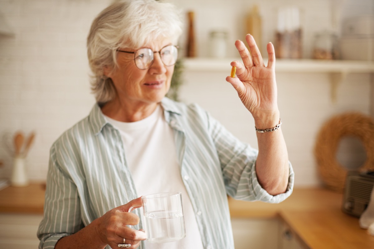 Woman taking pill or supplement