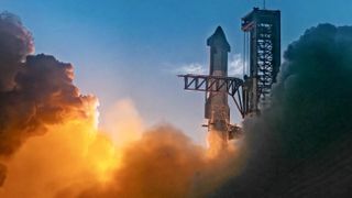 The top of a giant steel rocket just after liftoff, next to its black launch tower. Smoke glowed in orange swirls below, filling the frame on both sides.