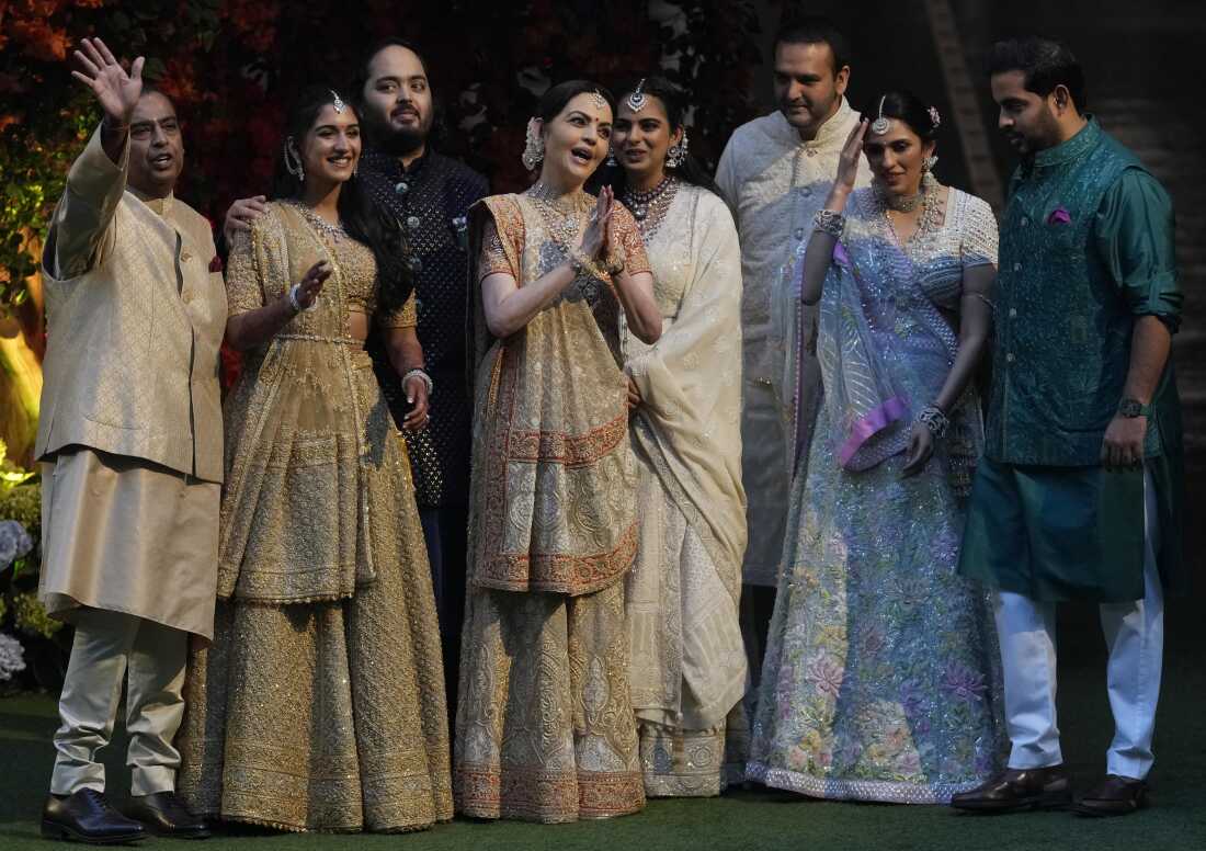 Reliance Industries Chairman Mukesh Ambani (L) waves to photographers as he poses with his family members on the occasion of the engagement of his son Anant Ambani (third from L) with Radhika Merchant (second from L) during a ceremony in Mumbai, January 19, 2023. 