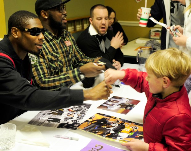 Pylesville's Matthew Wilson, right, gives Baltimore Ravens player Jacoby...