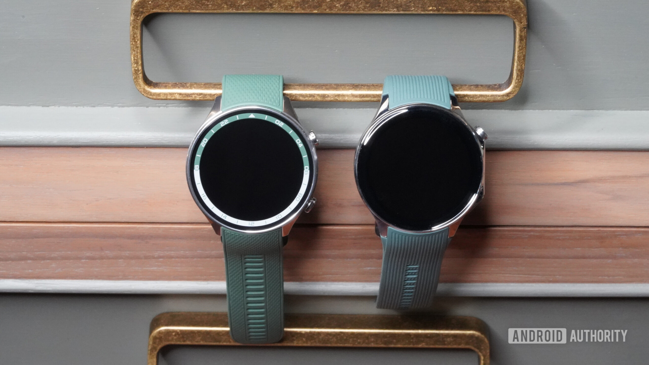 A OnePlus Watch 2R and a OnePlus Watch 2 are hanging side by side.