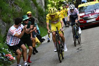 Slovenian rider Tadej Pogacar of UAE Team Emirates, wearing the yellow jersey of the general classification leader (L), takes the lead ahead of Danish rider Jonas Vingegaard (R) of Team Visma - Lease a Bike in the final climb of Plateau de Beille during the 15th stage of the 111th edition of the Tour de France cycling race, 197.7 km between Loudenvielle and Plateau de Beille, in the Pyrenees, southwestern France, on July 14, 2024. (Photo by Marco BERTORELLO / AFP)