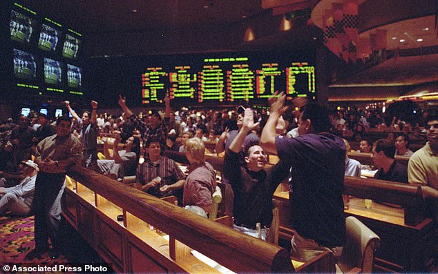 Dallas Cowboys fans Tom Connolly, left, and Eddie Hidalgo, of Los Angeles, celebrate in the sportsbook at the Mirage after winning one of their Super Bowl bets on January 28, 1996.