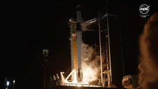 A rocket is launched into the darkness, surrounded by steam and launch towers