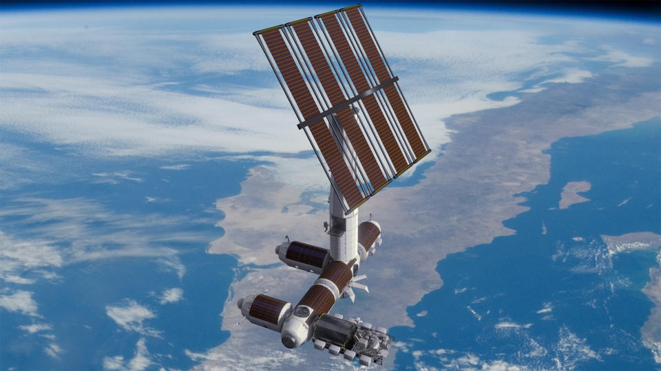 An E-shaped space station with a large array of solar panels floats above a blue and white Earth