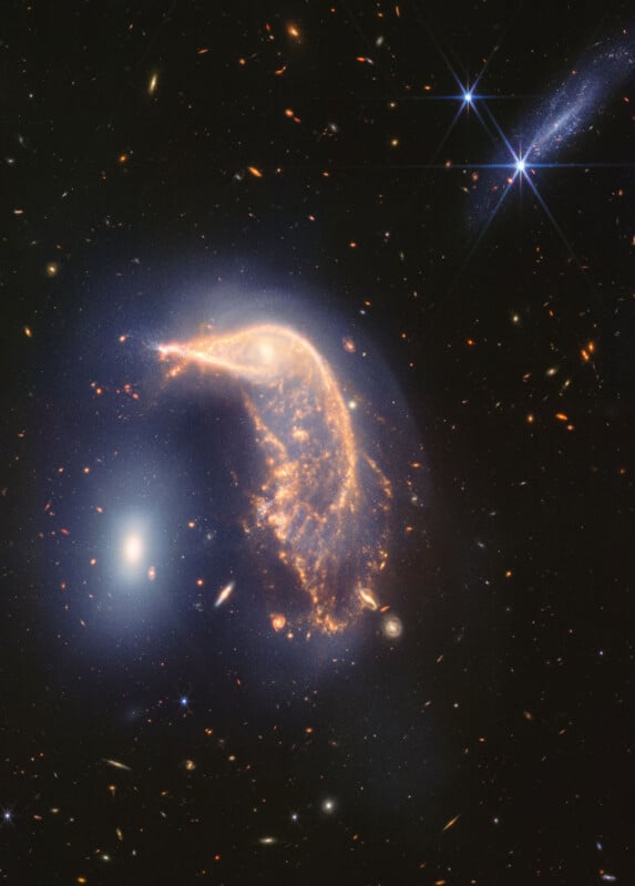 Image of a cosmic phenomenon captured by the Hubble Space Telescope. A bright, ethereal bird-shaped galaxy stands out against the dark, starry expanse of space. Bright light sources and smaller galaxies are visible in the background.