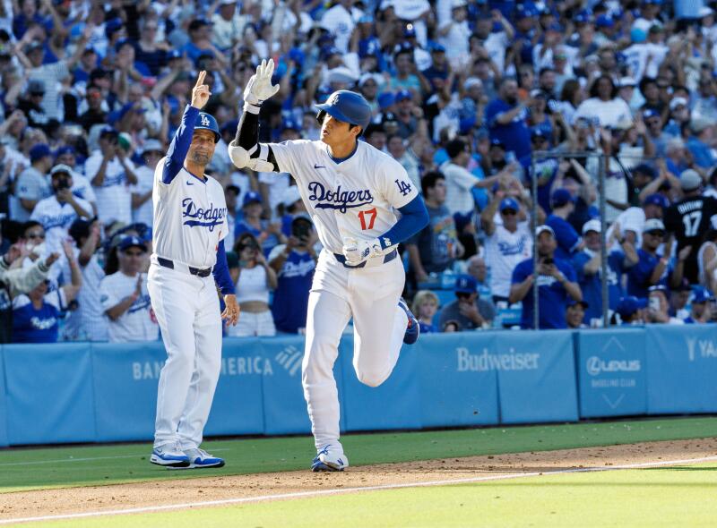 Shohei Ohtani celebrates with third base coach Dino Ebel after his solo home run at Dodger Stadium.